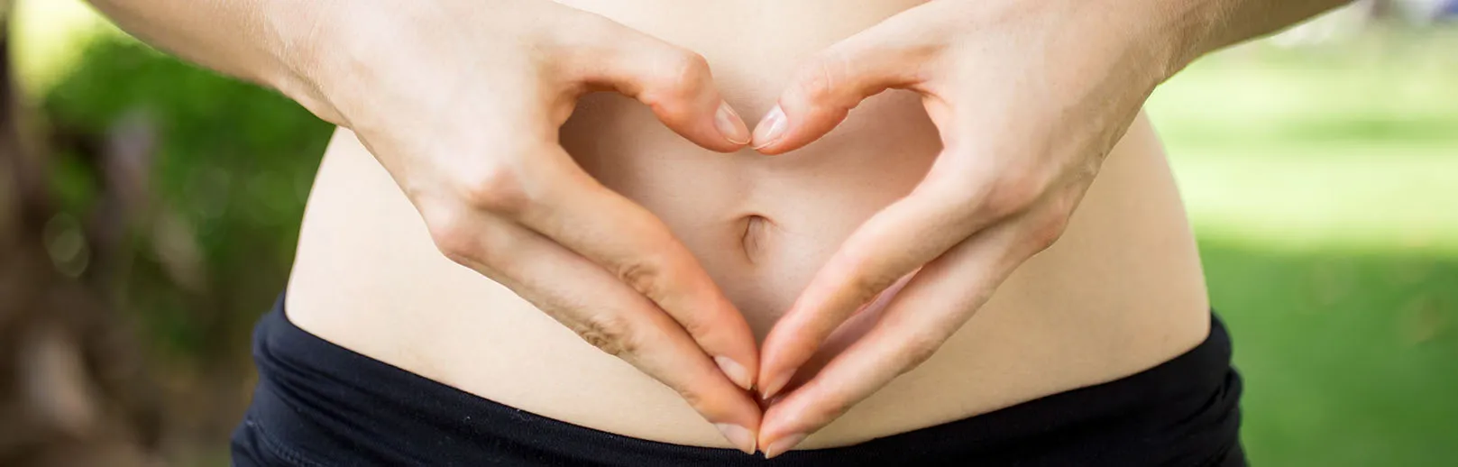 2024-close-up-female-hands-shaping-heart-belly Koloskopie – Darmspiegelung dr. Evelyn Ramsböck
