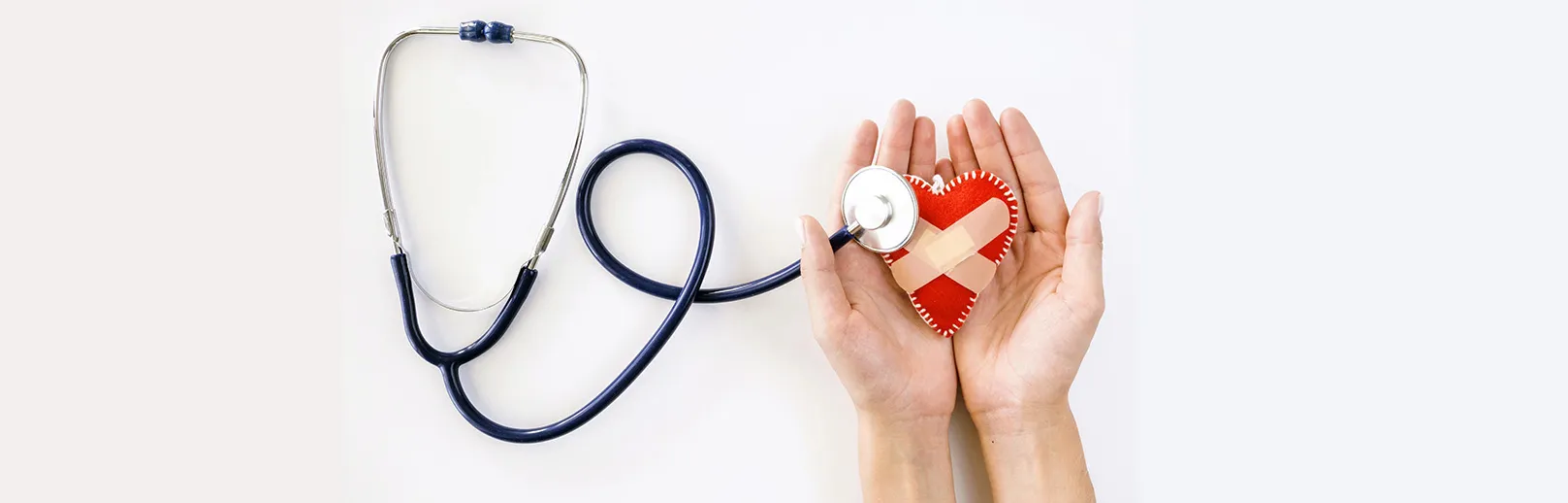 2024-top-view-hands-holding-damaged-heart-shape-with-stethoscope Mögliche Hinweise auf Herzerkrankungen Dr. Evelyn Ramsböck Haus Medicus